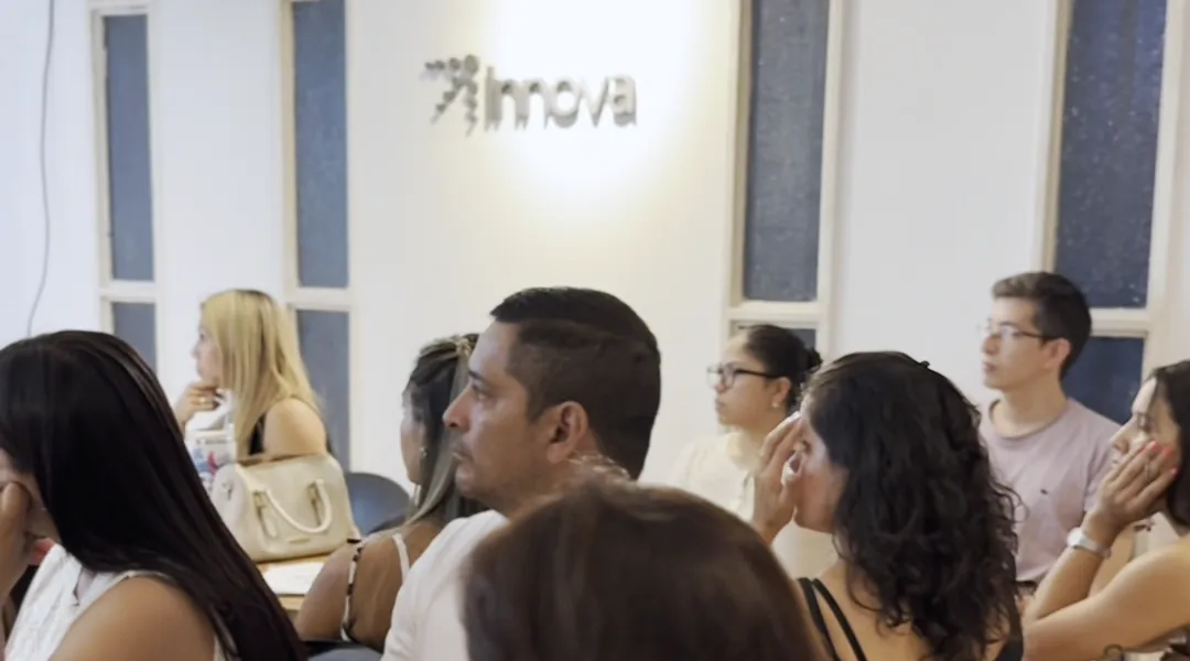Clase en el aula de Innova Center: alumnos sentados siguiendo la
                exposición, con el cartel de Innova en la pared del fondo